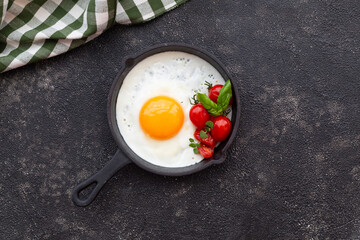 fried egg on a frying pan with cherry