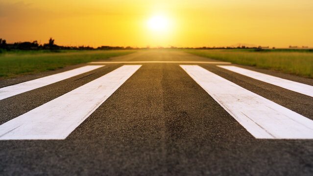 Runway at the airport in sunset sky