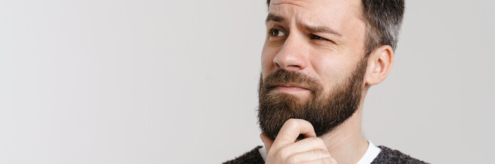 Obraz premium White puzzled man with beard posing and looking aside