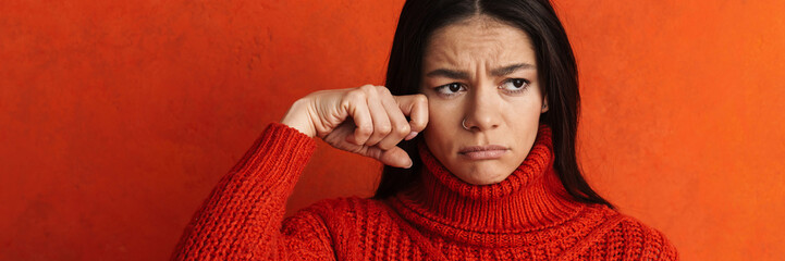 Young hispanic sad woman wearing sweater crying on camera