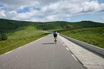 Male cyclist on a gravel bike is riding on the road in the hills with a view of the mountains.Sport...