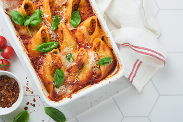 Cannelloni or conchiglioni. Baked stuffed pasta shells with bolognese meat sauce, tomatoes, basil...