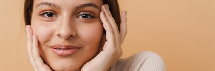 Young woman touching her face and smiling at camera