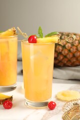 Tasty pineapple cocktail with mint and cherry on table