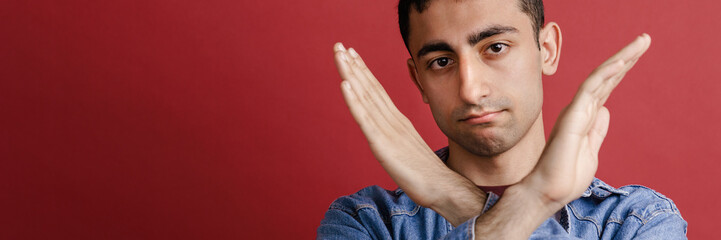 Obraz premium Young middle eastern man showing stop gesture at camera