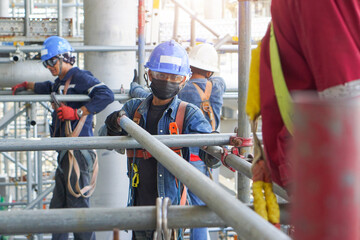 Worker's hand holding iron to installation scaffolding work for support building construction site...