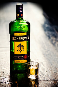 Slavsk / Ukraine - 07.22.2019: Bottle of Becherovka on wooden floor with glass, often used as a digestive aid is a an herbal bitters produced in Karlovy Vary, Czech Rep. in the center, space, no one