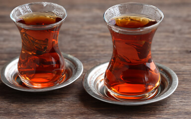 Turkish tea in traditional glass and metal teapot on wooden table closeup MADE OF AI