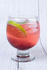 Flavored Italian sodas, tropical flavors, in a glass, with lots of ice, accompanied by mint leaf