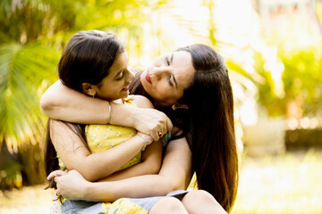 Fototapeta premium Happy southeast Asian mother with her daughter having fun in garden . mother hugs cute little girl showing love. family concept
