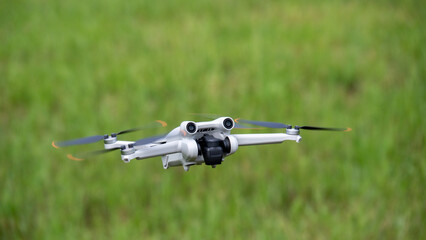 Camera drone flies over green meadow