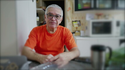 Portrait of a senior man in kitchen setting, elderly person looking at camera in domestic scene