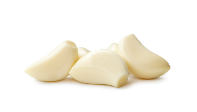 Peeled garlic cloves in stack isolated on white background with clipping path and shadow in png file format