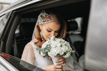 close-up portrait of a rather shy bride in a car window looking at her bouquet of flowers - obrazy, fototapety, plakaty