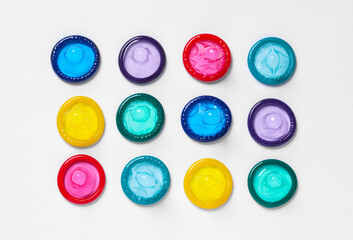 Colorful condoms on white background, flat lay. Safe sex