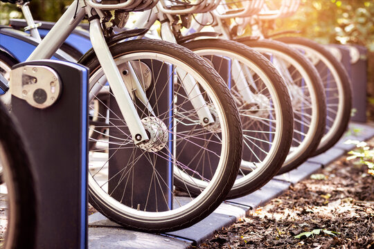 Electic Bikes on Charging Station in Parking Lot. Electro Bicycles for Rental Service Sharing System. e bike Eco Transport.