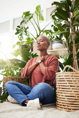 Wellness, peace and woman breathing by plants for meditation in a natural greenhouse. Breathe, gratitude and young calm African female person with a relaxing zen mindset by an indoor nursery garden.