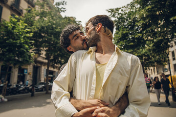 men couple walking kissing and huging in the city