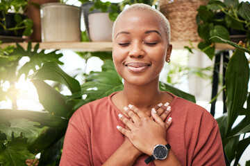 Zen, breathing and calm woman by plants for breathing exercise in meditation in a nursery. Breathe, gratitude and young African female person with a relaxing mindset by an indoor greenhouse garden.