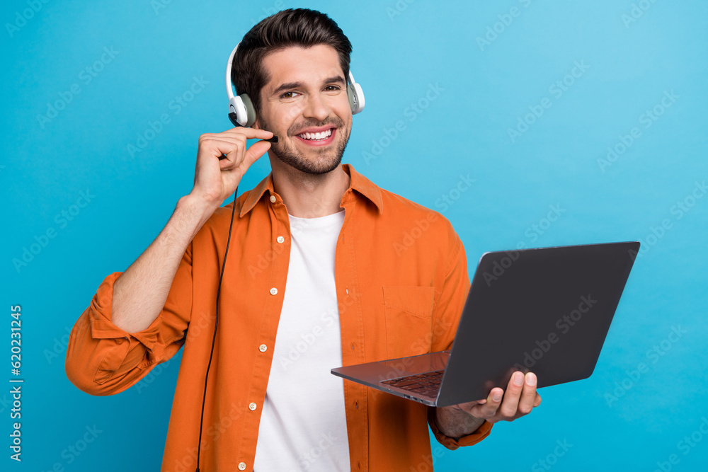 Poster Portrait of positive handsome guy helpdesk operator hand touch headset microphone use netbook isolated on blue color background