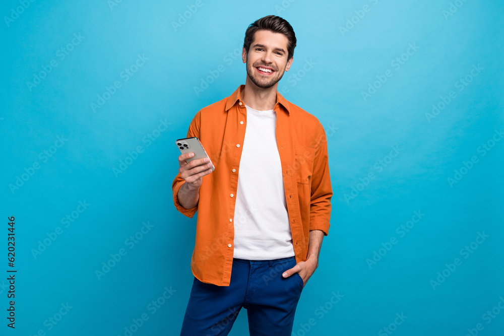 Poster portrait of positive nice person toothy smile hold use apple iphone texting chatting isolated on blu