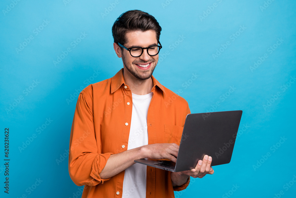 Poster portrait of handsome positive person beaming smile use wireless netbook coworking isolated on blue c