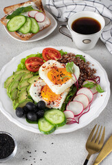 Healthy romantic breakfast - heart-shaped fried eggs served with avocado, spinach, quinoa, cherry tomatoes, radish, cucumber and black olives