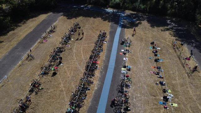 2023-06-25 - Upward Droneshot of transition area of a triathlon. Here triathletes switch between swimming, cycling and running.