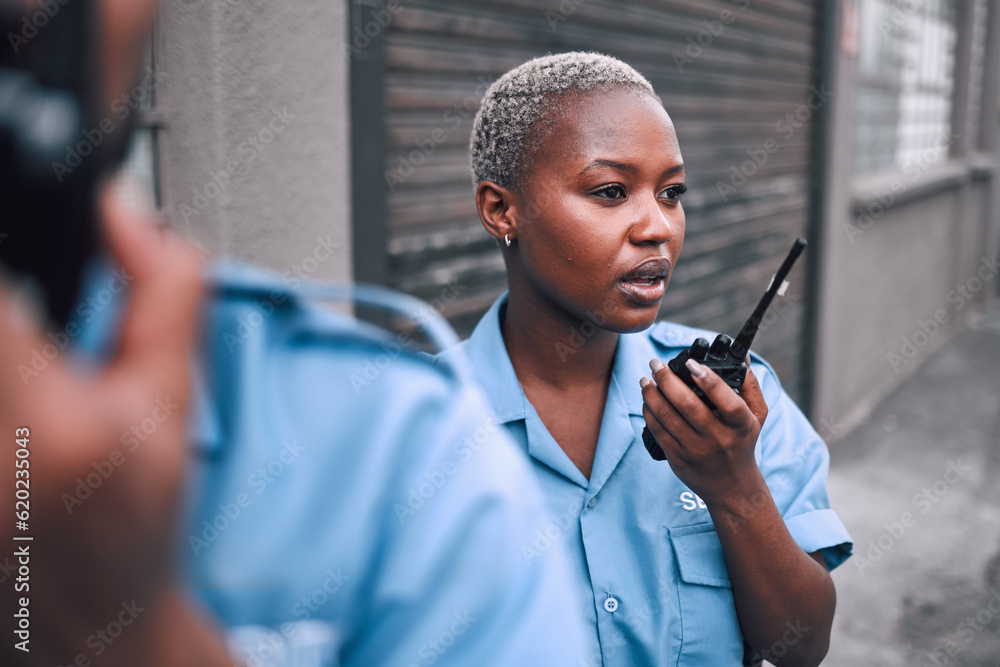 Wall mural Security, walkie talkie and a police woman in the city during her patrol for safety or law enforcement. Radio, communication and service with an african female guard on a street in an urban town