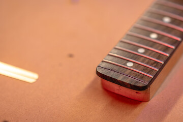 Unstrung Detached Guitar Neck Fretboard and Tools with Red Lighting, Macro, Wood Shop Luthier...