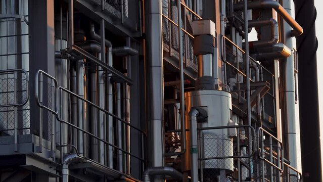 Industrial Pipelines details up close during sunset at paper mill factory in Northern Sweden.
