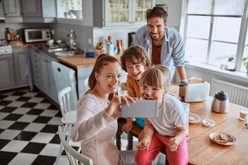 Young family taking a selfie while having breakfast in the morning