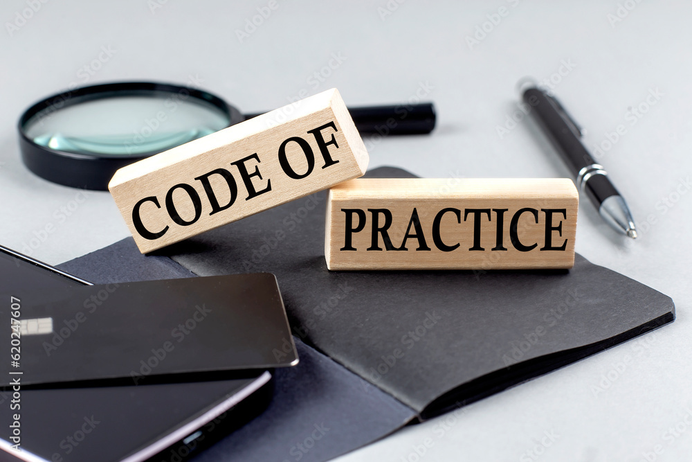 Poster code of practice text on wooden block on black notebook , business concept