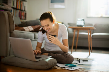 Young woman going over her bills and home finances in the living room
