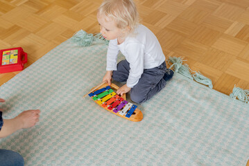 little child playing with toys, xylophone	
