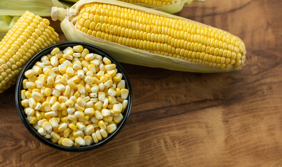 Corn on the cob with seeds on wooden table