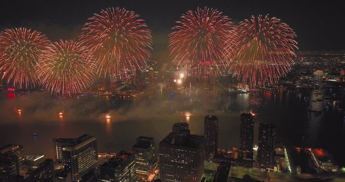 Cinematic Aerial Video of NYC's 4th of July Fireworks Light up the Night sky over tall dark buildings Manhattan Queens Brooklyn