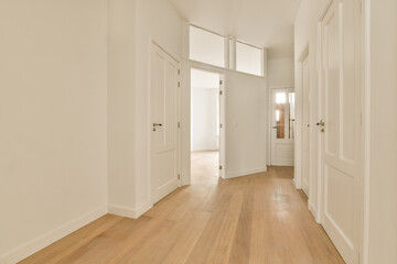 an empty room with white walls and wood flooring on the left side of the room, there is a door leading to another