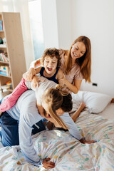 Young family playing together in the bedroom