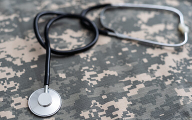 Closeup of a doctors stethoscope laying on old Military camouflage background