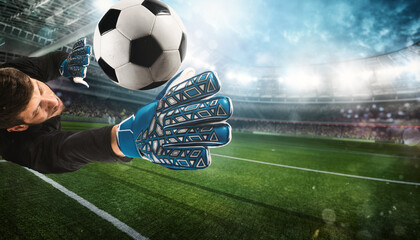 Close up of a goalkeeper catching the ball in the stadium during a football game © alphaspirit
