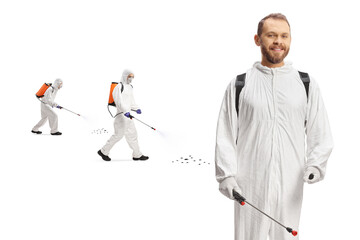 Pest control professionals in white suits spraying insects
