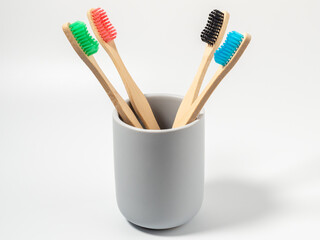 Bamboo toothbrushes in different colors. Wooden toothbrush on a white background. Toothbrush close-up.