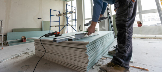 Workers assemble a suspended ceiling with drywall
