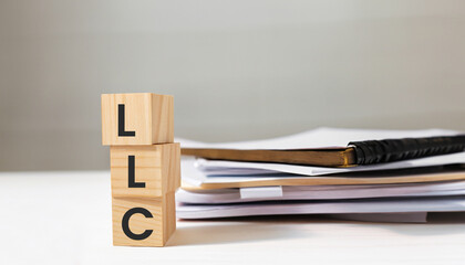 letter of the alphabet of LLC on a documents background. LLC - Limited liability company