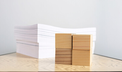empty wooden cube with stack of papers with documents