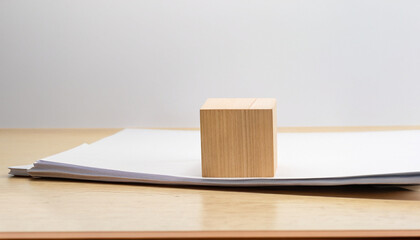 empty wooden cube with stack of papers with documents