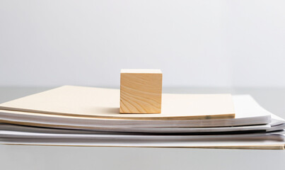 empty wooden cube with stack of papers with documents