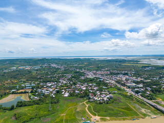 Aerial view of National Route 20 in Dong Nai province, group of floating house on La Nga river, Vietnam with hilly landscape and sparse population around the roads.