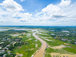 Aerial view of National Route 20 in Dong Nai province, group of floating house on La Nga river, Vietnam with hilly landscape and sparse population around the roads.